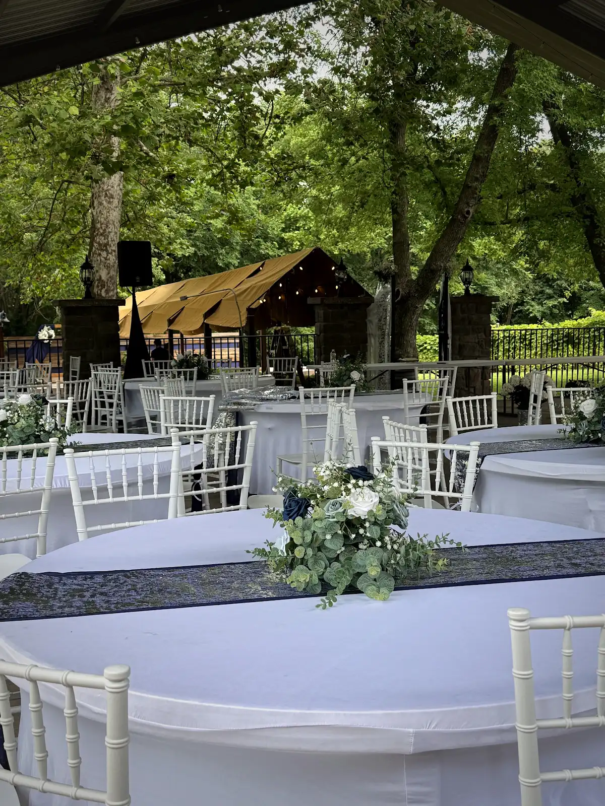 Wedding reception tables with white linens and floral centerpieces in the Pavilion